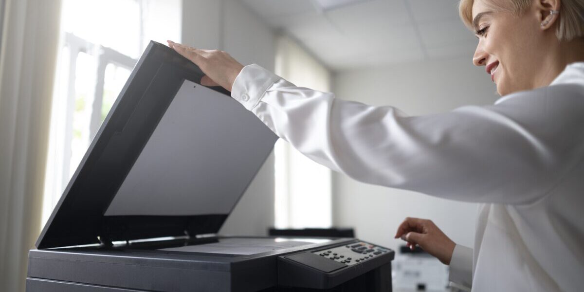 mujer-usando-impresora-mientras-trabaja-en-la-oficina (1) impresora multifunción para empresas